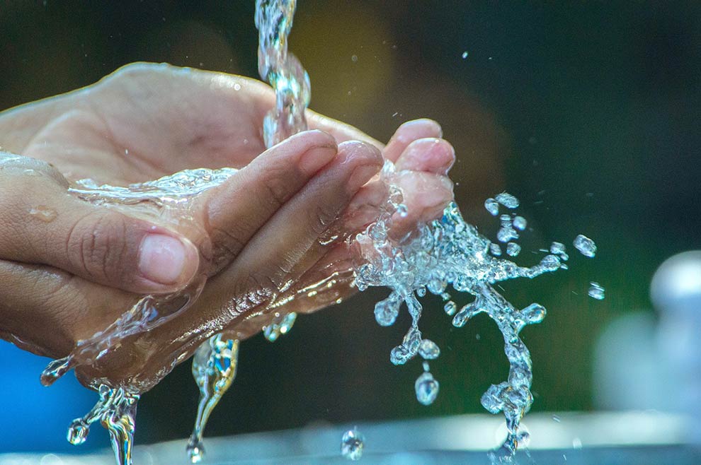 Ein Mensch wäscht sich die Hände zur Symbolisierung von klarem und sauberen Wasser